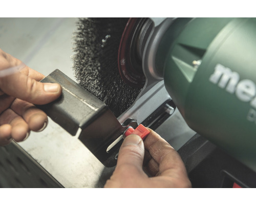 Persoană șlefuind o piesă cu o mașină de șlefuit Metabo