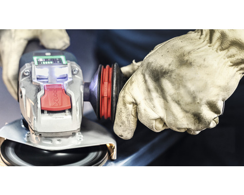 Polizor unghiular cu o singură mână cu sistem X-Lock și mănuși în uz.