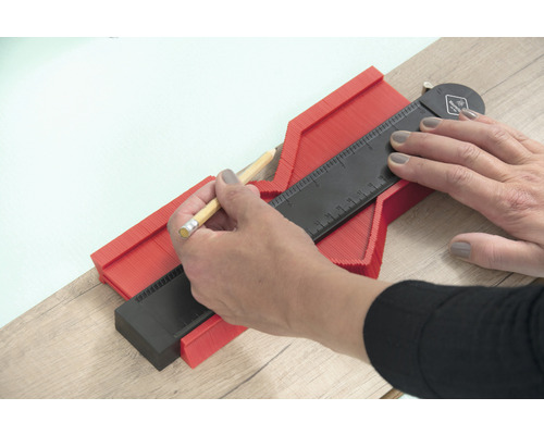 O persoană folosește un șablon de contur pentru a transfera forme.