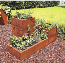 Jardiniere metalice stratificate în grădină cu diverse plantații.