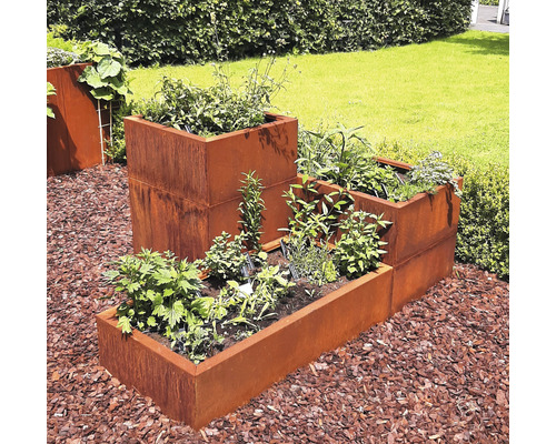 Jardiniere metalice stratificate în grădină cu diverse plantații.