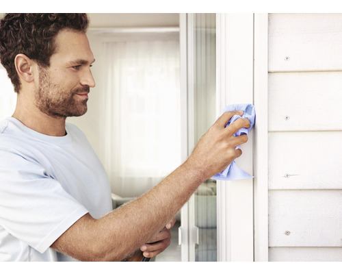 Bărbat care curăță rama ferestrei cu o cârpă