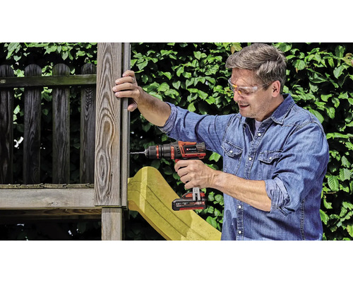 Un bărbat fixează o bucată de lemn cu o șurubelniță fără fir.