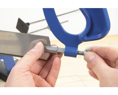 Prim-plan cu un ferăstrău pentru metal fixat de o mână