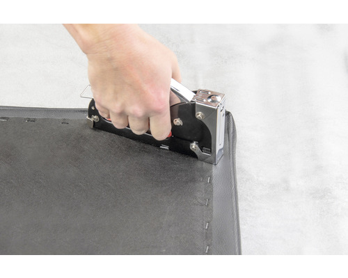 Utilizarea unui capsator manual pe o țesătură neagră