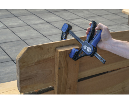 Mână fixează piese de lemn cu o menghină cu o singură mână