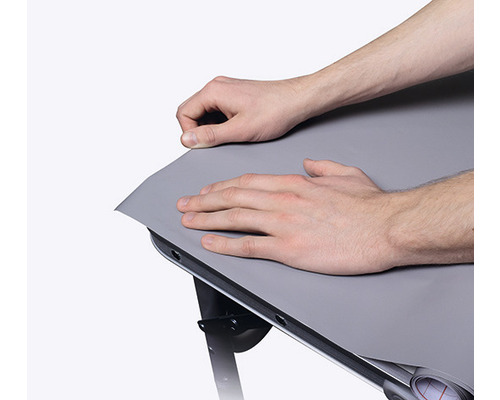 Persoană care fixează o folie de masă pe o masă