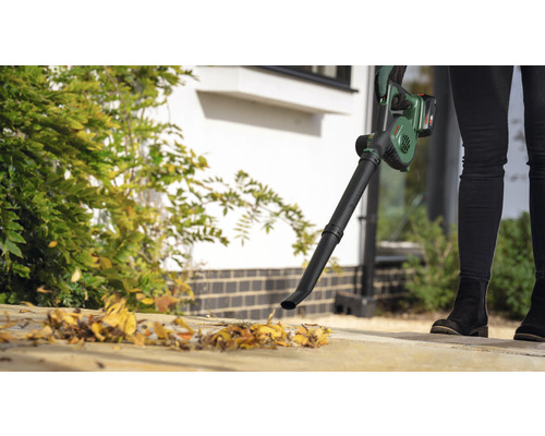 O persoană folosește o suflantă de frunze fără fir pentru lucrări de grădinărit.