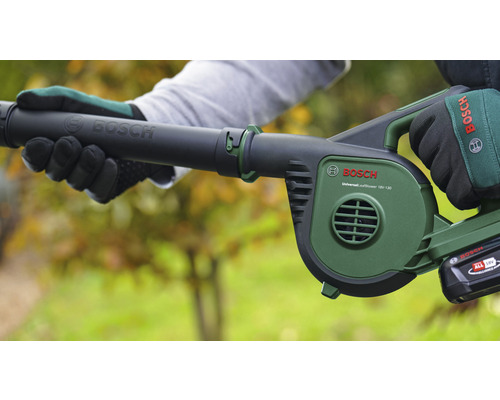 O persoană ține în mână o suflantă de frunze cu acumulator marca Bosch.