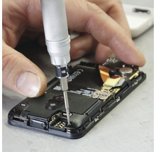 Un bărbat repară un smartphone cu o șurubelniță