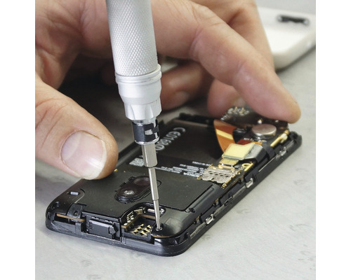 Un bărbat repară un smartphone cu o șurubelniță