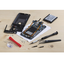 Imagine cu un telefon mobil dezasamblat cu instrumente pentru reparații