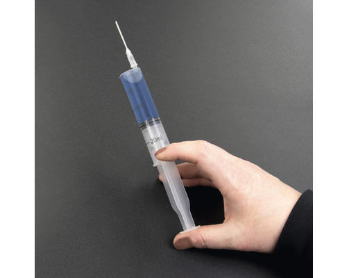 O mână ține o seringă de 20 de mililitri cu ac.