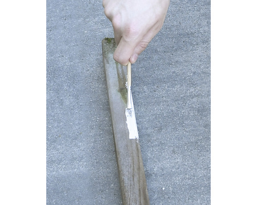 Vopsirea unui stâlp de lemn cu o pensulă