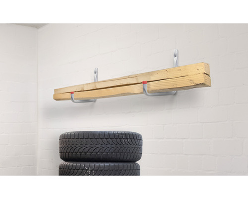 Scânduri de lemn pe cârlige de perete și anvelope stivuite