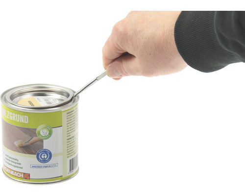 O persoană deschide o cutie de grund pentru lemn cu o unealtă