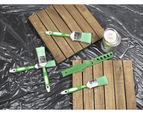 Scenă cu plăci de lemn, pensule, cutie de vopsea și instrument pentru amestecarea vopselei