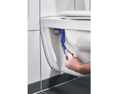 Mână care folosește o unealtă pentru a repara o toaletă