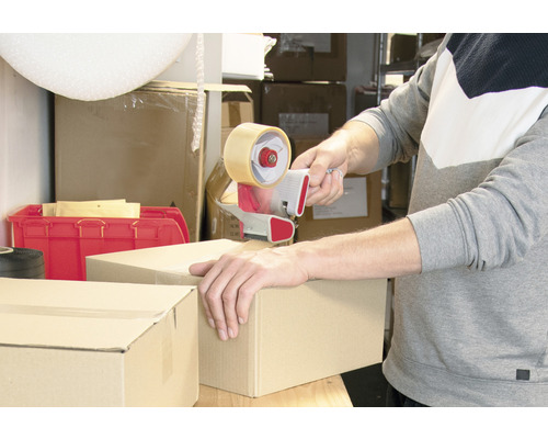 O persoană sigilează o cutie de carton cu un derulator manual.