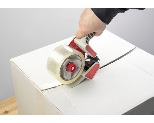 Cutia de carton este închisă cu un aplicator de bandă adezivă