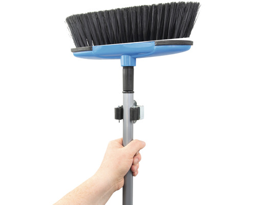 Mână care ține o mătură cu mâner telescopic