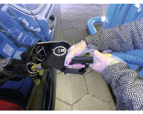 O persoană alimentează o mașină cu motorină la o stație de alimentare