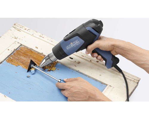 Pistol cu aer cald în timpul îndepărtării vopselei de pe o ușă