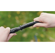 Două mâini conectează un furtun de irigare.