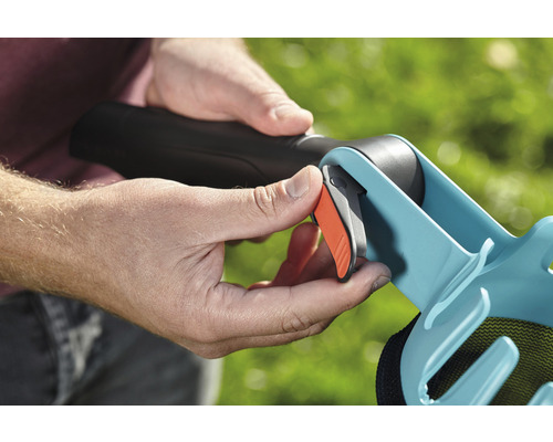 Persoană acționând declanșatorul unui colector de frunze.