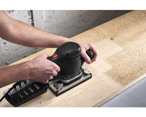 O persoană șlefuiește lemn cu o șlefuitoare orbitală.