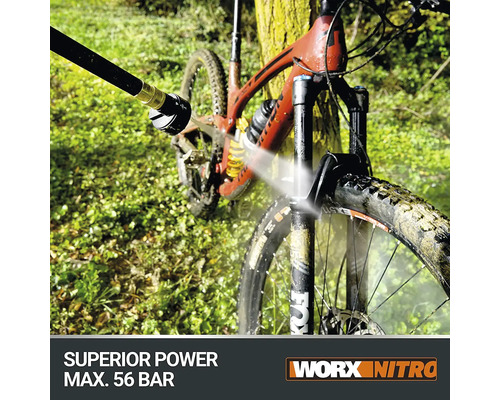 Un mountain bike este curățat cu un aparat de curățat cu presiune. Logo Worx Nitro.