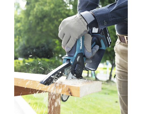 Fierăstrău cu acumulator utilizat la tăierea unei bucăți de lemn.