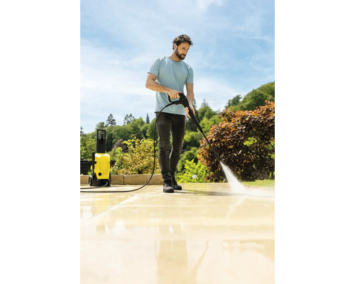 Bărbat curățând terasa cu un aparat de curățat cu presiune