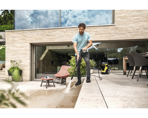 Bărbat curăță terasa cu un aparat de curățat cu presiune