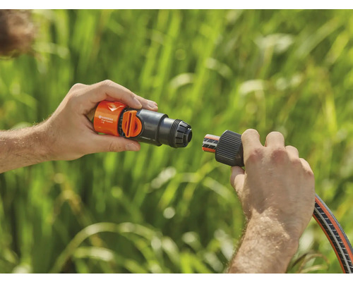 O persoană conectează o piesă de furtun Gardena la o conexiune de robinet.