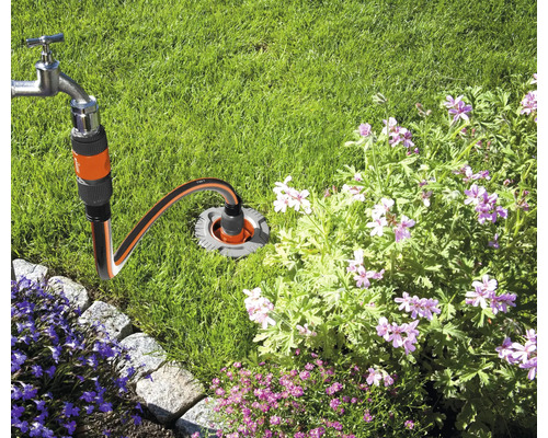 Robinet de apă conectat la o conexiune subterană de apă în grădină.