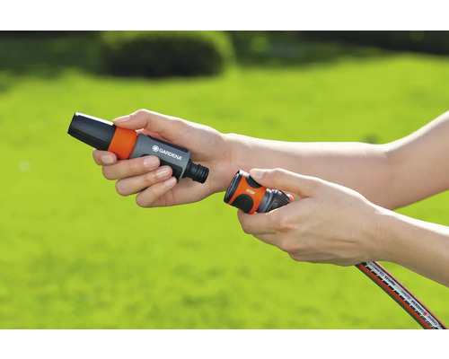 Persoană care conectează cuplaje pentru furtun de grădină Gardena.