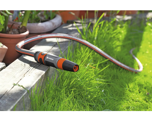 Furtun de grădină Gardena cu pulverizator pe o suprafață din lemn