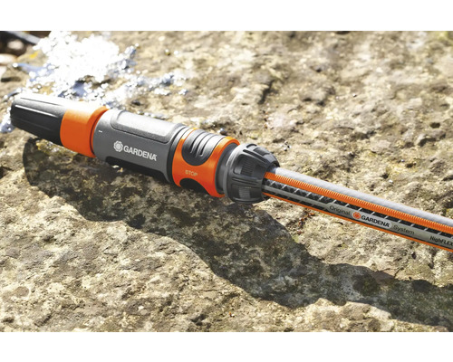 Conector furtun Gardena cu furtun de apă pe o suprafață de piatră