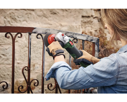 Femeie șlefuind o balustradă metalică cu un polizor unghiular