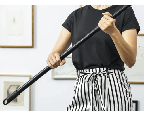 O persoană ține un mâner de mop negru.
