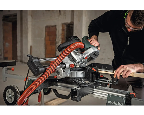 Bărbat taie lemn cu un ferăstrău circular Metabo pe o masă de tăiat