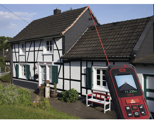 Un telemetru laser măsoară lungimea acoperișului unei case.