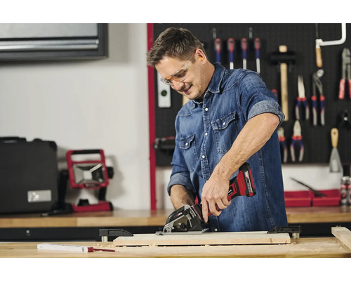 Bărbat care lucrează cu un ferăstrău circular portabil fără fir pe o bucată de lemn