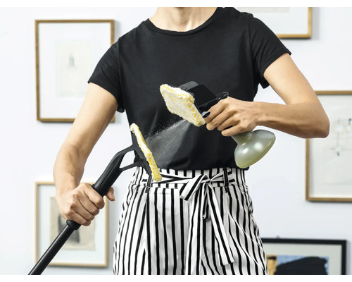 Femeie care folosește un aparat de curățat cu abur cu diferite accesorii pentru curățare