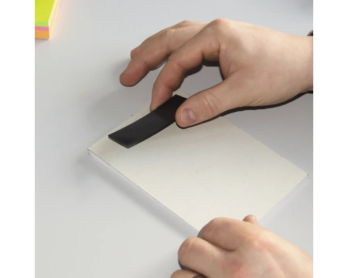 Mână cu bandă magnetică pe carton alb