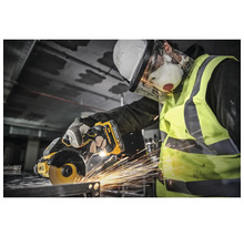 Muncitor cu cască de protecție, ochelari de protecție, mască de protecție respiratorie și vestă de avertizare care taie metal cu un polizor unghiular DeWalt.