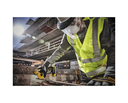 Un meșter cu ochelari de protecție și vestă de avertizare taie o bucată de metal cu o mașină de șlefuit DeWalt.