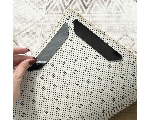 Două colțare antiderapante pentru covoare pe un covor pentru fixare și menținere.