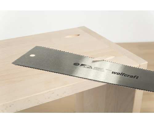 Fierăstrău manual marca Wolfcraft în timpul tăierii lemnului